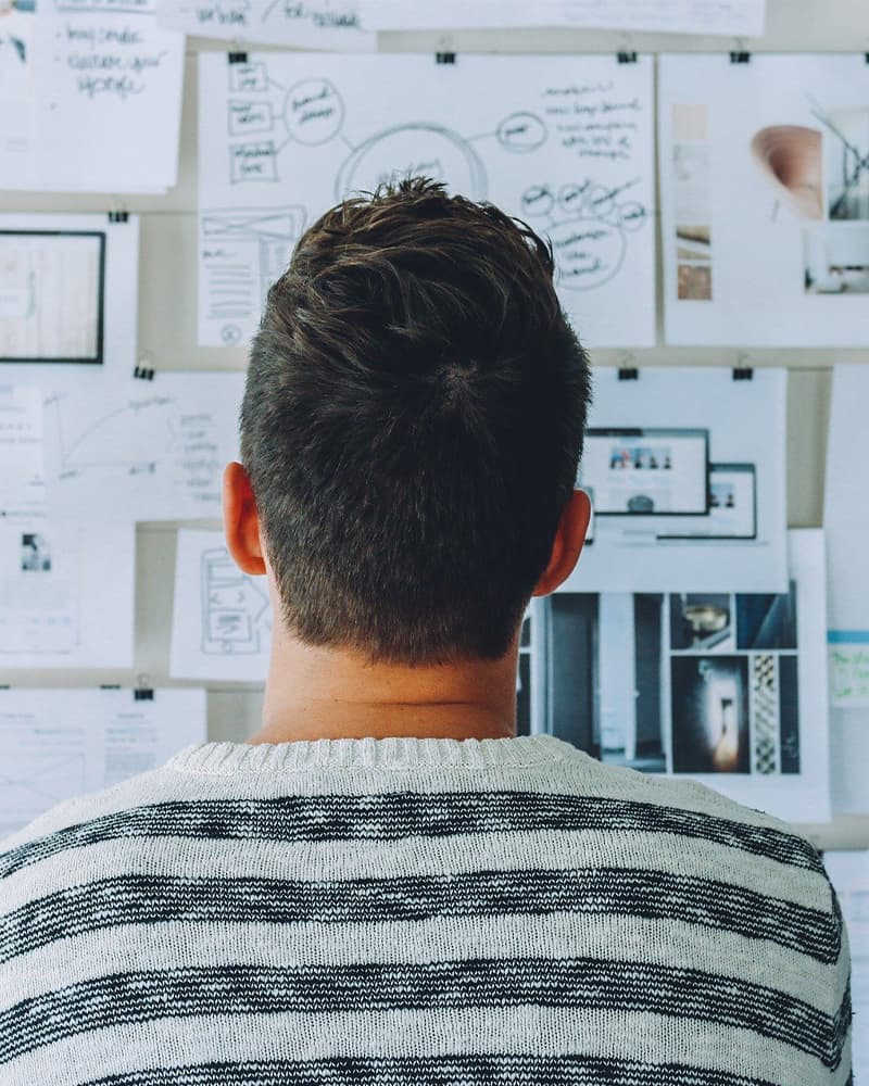 A man in front of a wall with papers